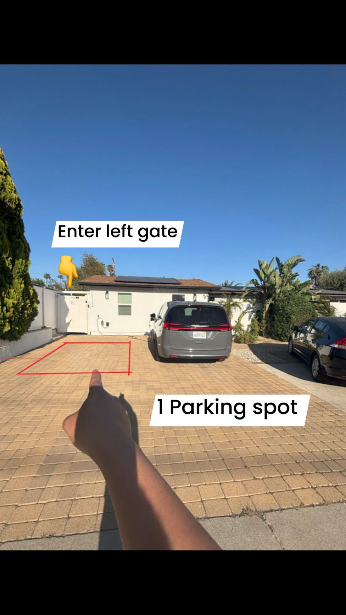 Driveway view showing the reserved parking spot outlined in red and the left gate to enter
